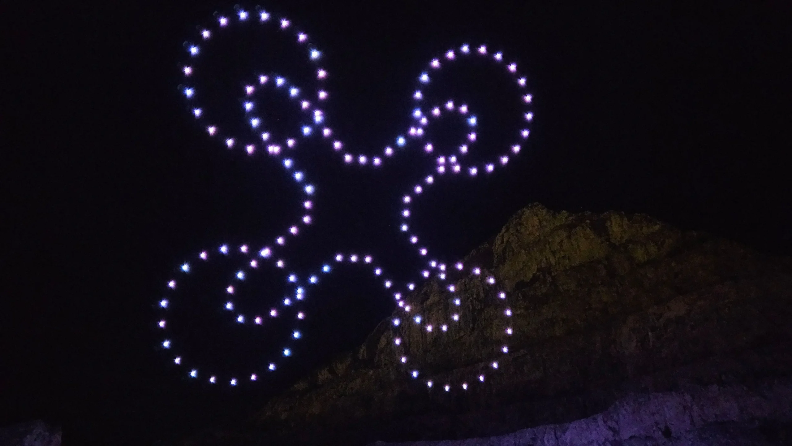 Svjetlosna drone show formacija drona na noćnom nebu