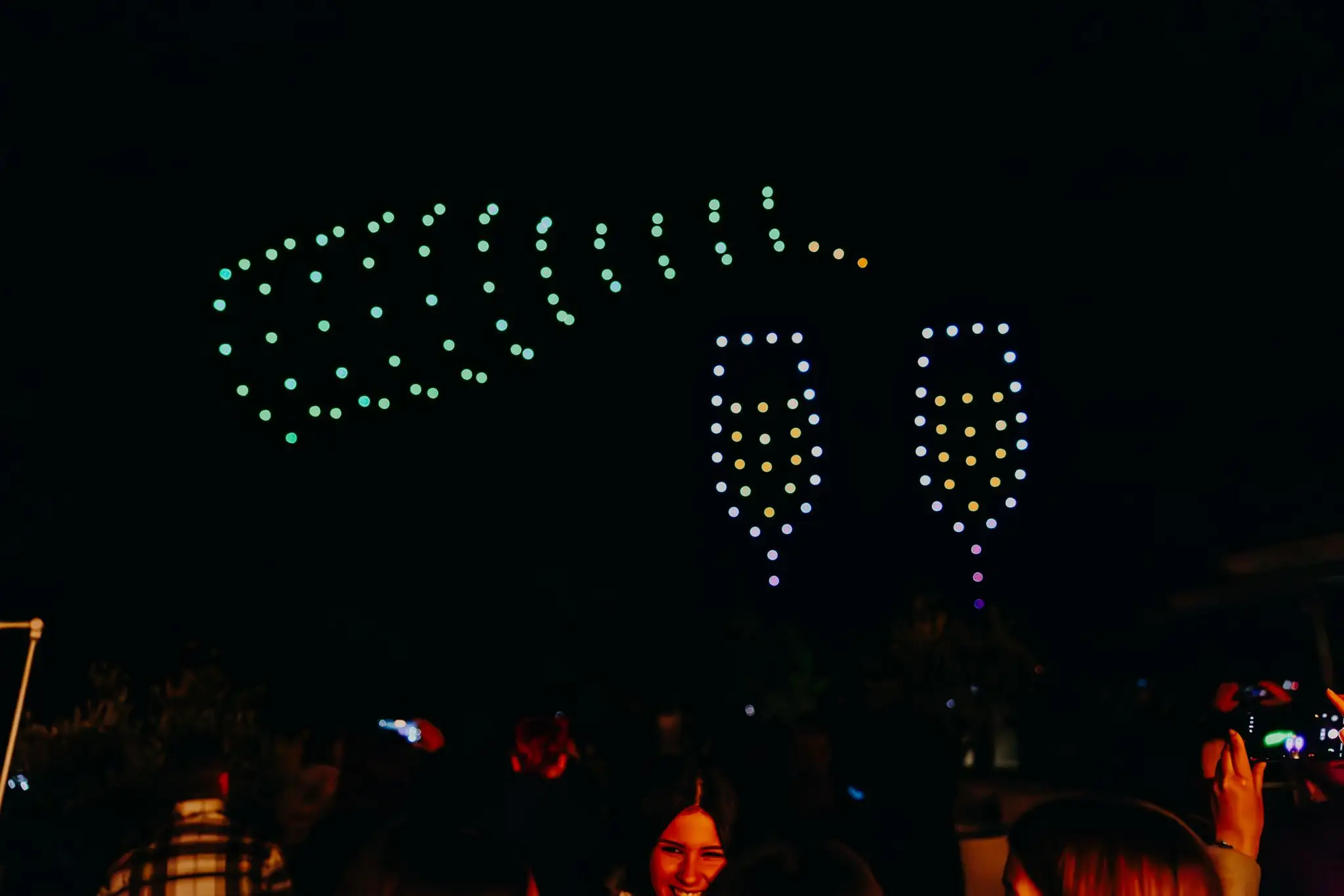 Svjetlosna drone show formacija boce šampanjca i čaša tijekom proslave