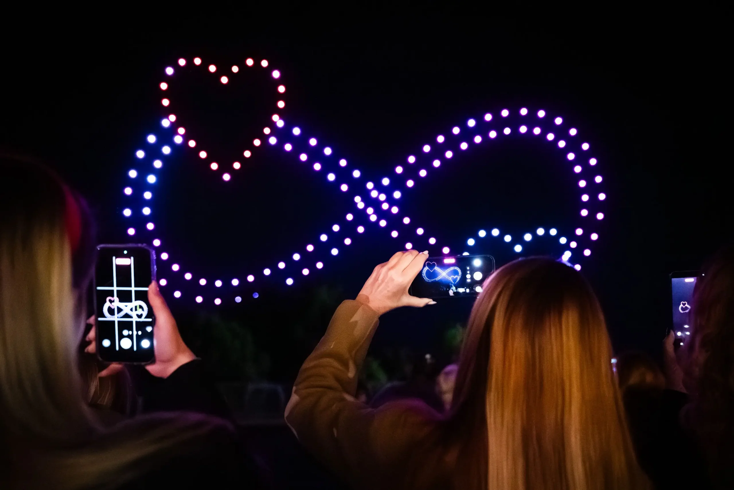 Publika fotografira infinity drone light show formaciju tijekom vjenčanja i eventa
